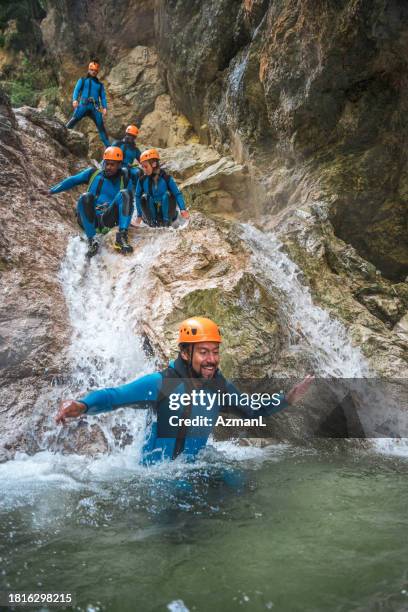 diverse group having fun canyoning slide - slovenia spring stock pictures, royalty-free photos & images