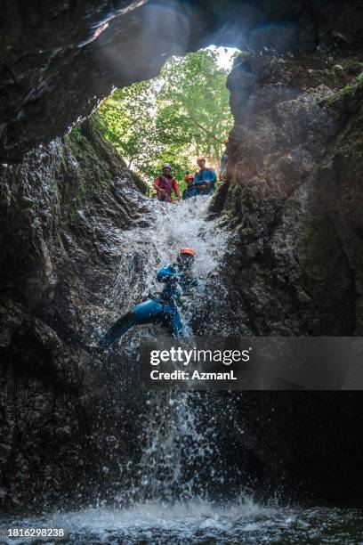 rappelling down waterfall in canyoning expedition - slovenia spring stock pictures, royalty-free photos & images