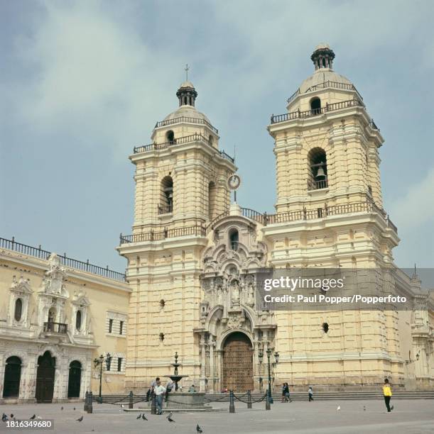 Pedestrians walk past the Basilica and Convent of San Francisco, a church and convent in the centre of the city of Lima, capital of Peru, South...