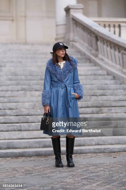 Gabriella Berdugo wears a leather cap hat from Kroyn, a blue shearling leather coat from Saks Potts, black leather square toe boots from AGL, during...