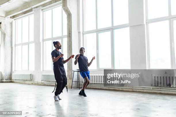 two black men dancing together at dance lesson in exercise room - tribal dancing stock pictures, royalty-free photos & images