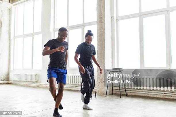 two black men dancing together at dance lesson in exercise room - tribal dancing stock pictures, royalty-free photos & images