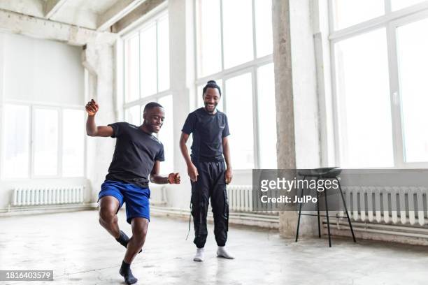 two black men dancing together at dance lesson in exercise room - tribal dancing stock pictures, royalty-free photos & images