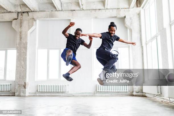 two black men dancing together at dance lesson in exercise room - tribal dancing stock pictures, royalty-free photos & images