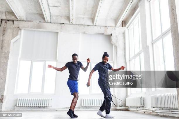 zwei schwarze männer tanzen zusammen bei der tanzstunde im fitnessraum - contemporary dance stock-fotos und bilder