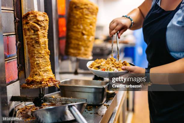 food-service-mitarbeiter bereitet salat mit gyros-fleisch in einem diner zu - shawarma stock-fotos und bilder