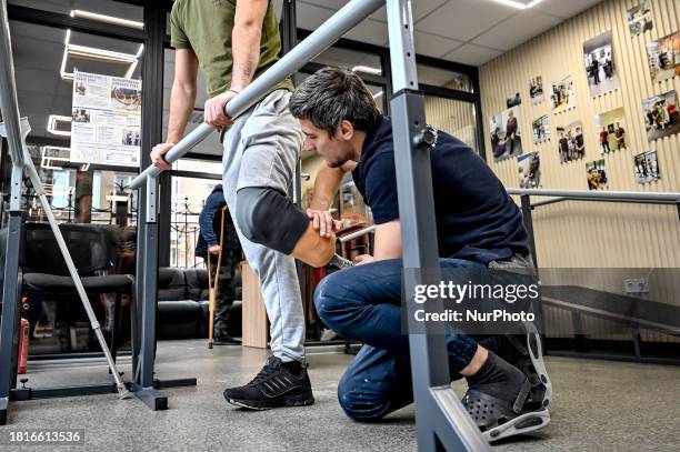 Prosthetist Oleksii Yatsenko is assisting serviceman Andrii with the fitting of a prosthetic leg at the Prosthetics and Rehabilitation Centre in...