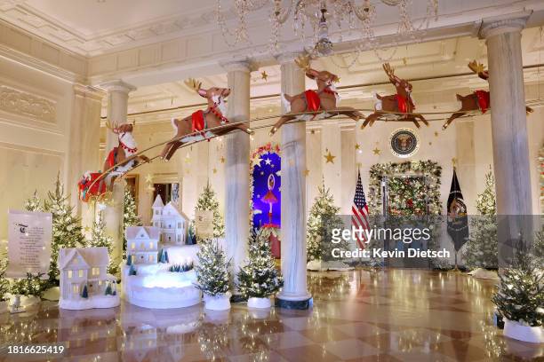 Santa Clause in his sleigh and a team of reindeer fly through the columns of the Entrance Hall during a media preview of the 2023 holiday decorations...