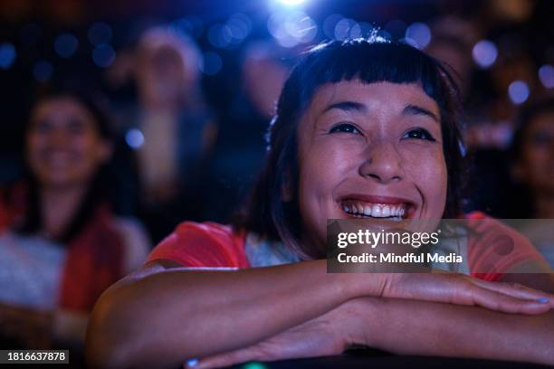 vista frontal da jovem mulher asiático-americana desfrutando de um filme dentro do cinema - indian couple in theaters - fotografias e filmes do acervo