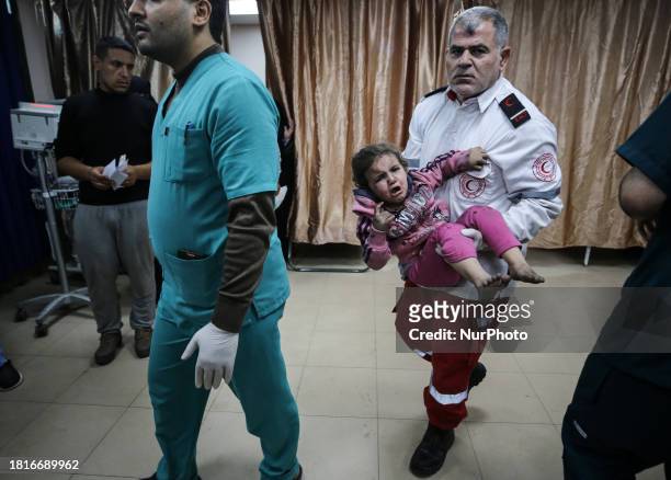 Palestinian paramedic is carrying an injured girl at the Al-Aqsa hospital in Deir Balah, in the central Gaza Strip, on December 2 amid ongoing...