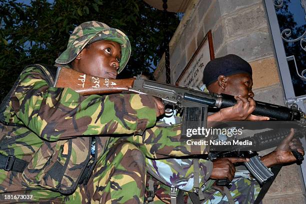 Officers take cover at Westgate Mall during a shoot-out with the terrorists on September 23, 2013 in Nairobi, Kenya. The attack occurred on Saturday,...