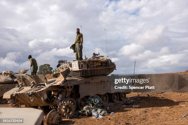Members of the Israeli Defense Forces work on a tank at a staging area near the border of Gaza as a four day cease fire between Israel and members of...