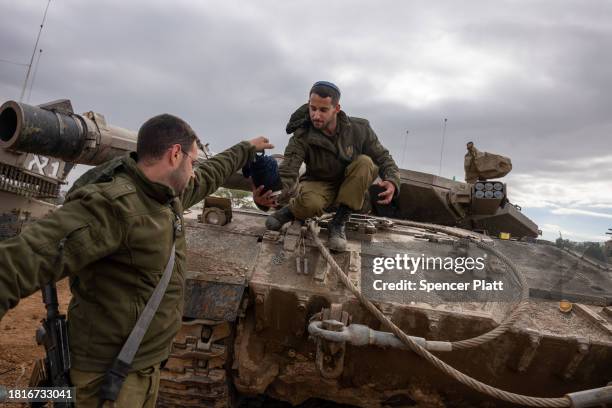 Members of the Israeli Defense Forces work on a tank at a staging area near the border of Gaza as a four day cease fire between Israel and members of...