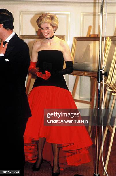Diana, Princess of Wales, wearing a red taffeta and black velvet Flamenco ball gown designed by Murray Arbeid, a choker and red and black gloves,...