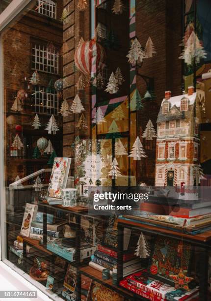 vintage charm: christmas window decor at london's classic bookstoreation - storefront-for-art-and-architecture stock pictures, royalty-free photos & images