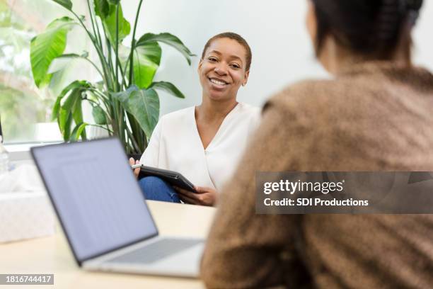 female manager listens to presentation by unrecognizable female employee - performance review stock pictures, royalty-free photos & images