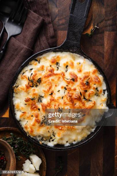 mac and cheese with thyme in cast iron skillet - cheese sauce stock pictures, royalty-free photos & images