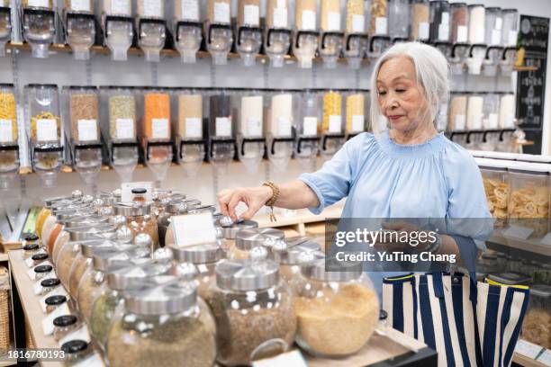 senior lady engages in eco-conscious shopping - yuting stock pictures, royalty-free photos & images