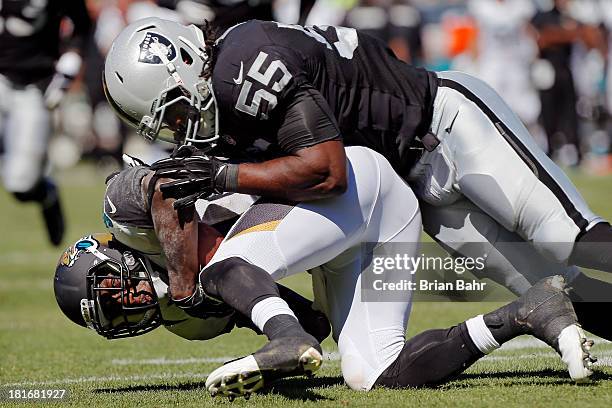 Running back Jordan Todman of the Jacksonville Jaguars grabs a pass against Sio Moore of the Oakland Raiders in the second quarter on September 15,...