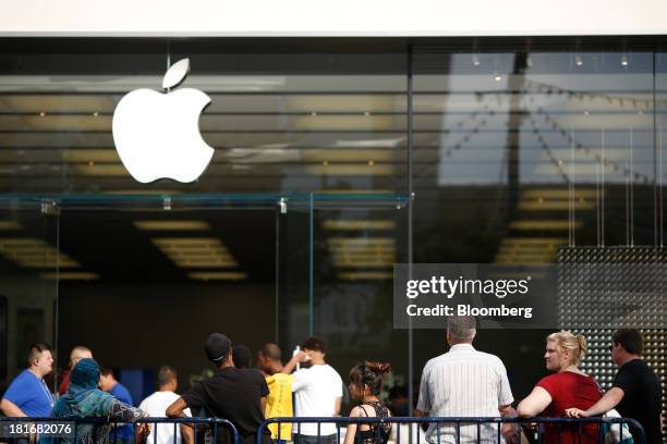 Customers wait in line outside an Apple Inc. Store to purchase at Easton Town Center in Columbus, Ohio, U.S., on Friday, Sept. 20, 2013. The U.S....