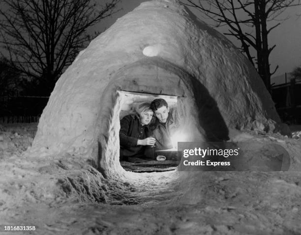David Evans-Jones and Janet Brazier illuminated as they sit in the igloo they built in the garden of David's home in Beckenham, Kent, England, 2nd...