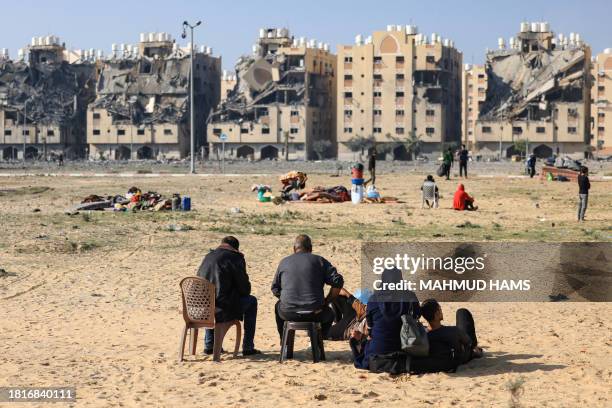 Residents of the Qatari-funded Hamad Town residential complex in Khan Yunis in the southern Gaza Strip, sit with some of their belongings as they...