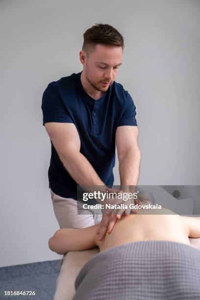 massage therapist masseur massages patient back, relieving tension from muscles and toning up - hernia recovery stock pictures, royalty-free photos & images