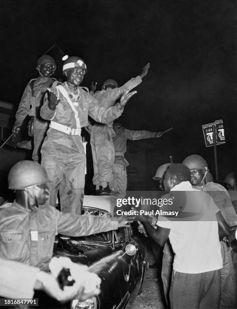 Military personnel seek to calm an anti-colonial demonstrator in Leopoldville, Belgian Congo, January 1959. Riots broke out after members of the...