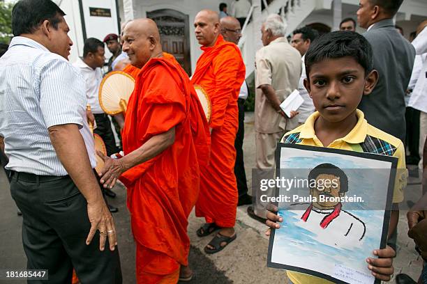 Boy holds a drawing of Sri Lankan President Mahinda Rajapaksa during an opening of the Sumanadasa Abeygunaward Astrological library in Galle. Sri...