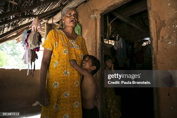 Tamil war victim Rajani grabs onto his grandmother, Indra Devi, outside their house in Mullaitivu, Sri Lanka, July 9, 2013. Rajani's mother was...