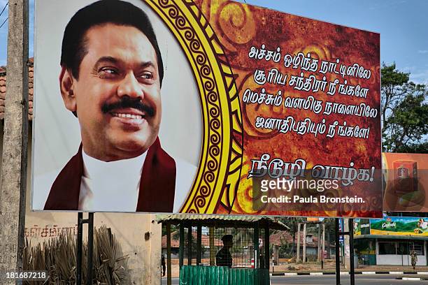 Giant poster of President Mahina Rajapaksa is seen as military stands guard outside of Jaffna, Sri Lanka, July 9, 2013. War's end has unleashed...