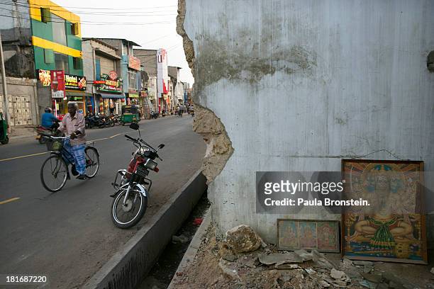 People and traffic move by war torn buildings in downtown Jaffna, Sri Lanka, July 9, 2013. War's end has unleashed Sinhalese nationalism that has...