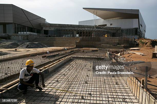 Sri Lankan construction workers build a new convention center after years of falling behind schedule in Hambantota, July 6, 2013. War's end has...