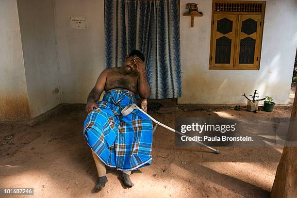 Tamil War Victim Ravi Chandran, who is a double amputee, sits outside his house in Mullaitivu, Sri Lanka, August 25, 2013. War's end has unleashed...