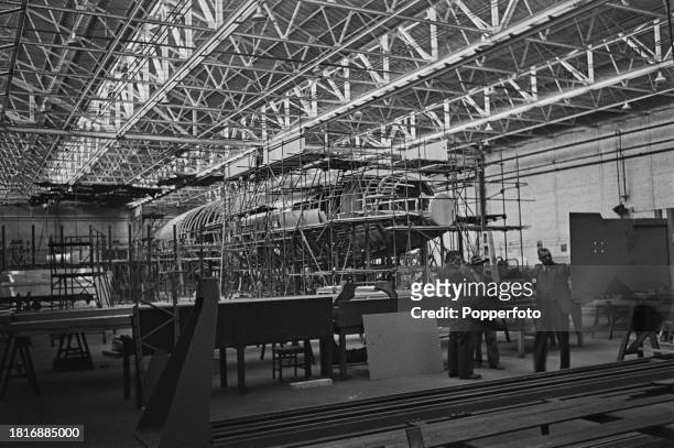 Employees at work constructing a wooden mock-up fuselage of the prototype Bristol Brabazon propeller-driven airliner in a hanger at the Bristol...