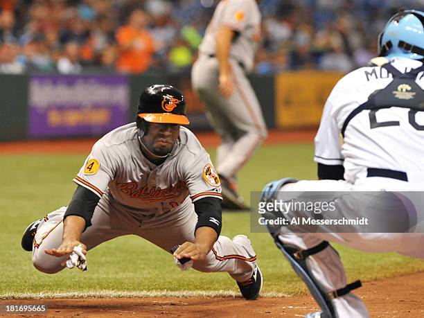 Infielder Alexi Casilla of the Baltimore Orioles slides into home plate in the 7th inning against the Tampa Bay Rays September 23, 2013 at Tropicana...
