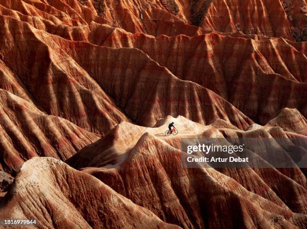 mountain biker descending between the surreal badlands desert formations in spain. - trilho para bicicleta desporto ao ar livre imagens e fotografias de stock