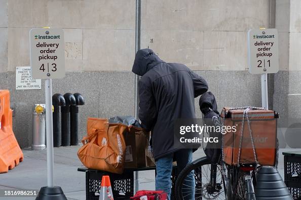Worker at Instacart delivery order pickup area, outside Wegmans Astor Place Worker at Instacart delivery order pickup area, outside Wegmans Astor Place