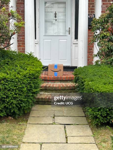 Single Amazon package on stoop of residential building, Queens, New York.