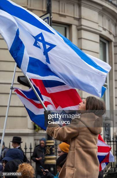 London, UK, November 26 2023, A young girl carries an Israeli flag at the "March Against Antisemitism" in support of hostages taken by Hamas in Gaza.