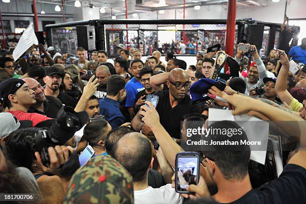 Mixed martial artist Anderson Silva of Brazil autographs memorabilia for fans after a Q&A session at UFC Gym on September 23, 2013 in Torrance,...