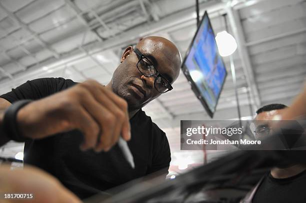 Mixed Martial Artist Mixed martial artist Anderson Silva of Brazil autographs UFC memorabilia after a Q&A session at UFC Gym on September 23, 2013 in...