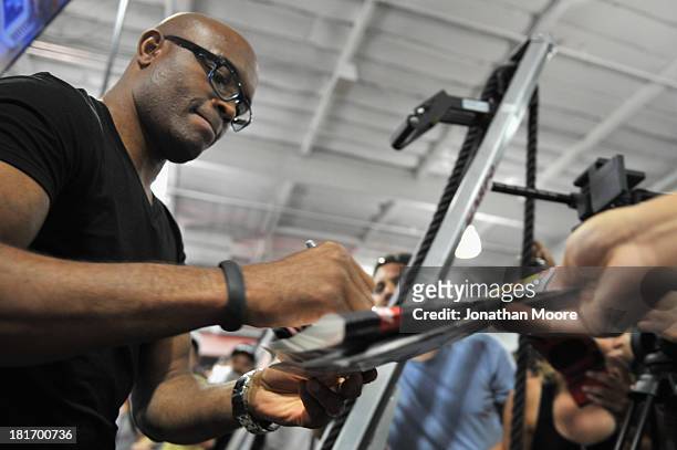 Mixed martial artist Anderson Silva of Brazil autographs UFC memorabilia for fans during a Q&A session at UFC Gym on September 23, 2013 in Torrance,...