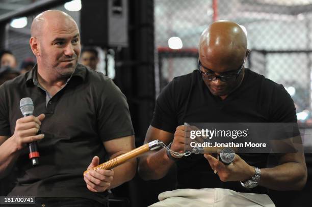 Mixed martial artist Anderson Silva of Brazil autographs a pair of nunchucks along side the UFC President Dana White during a Q&A session at UFC Gym...