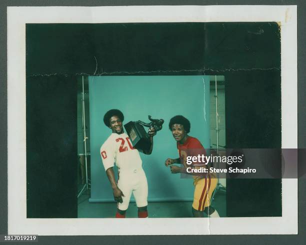 Portrait of American football players Billy Sims , holding the Heisman Trophy, and Charles White , Los Angeles, California, 1979. Sims was the...