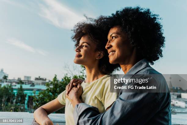 mère et fille admirant la vue ensemble sur le balcon - afro caraïbien photos et images de collection