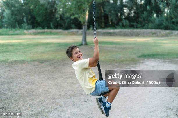 boy swinging on rope swing,spain - peel park stock pictures, royalty-free photos & images