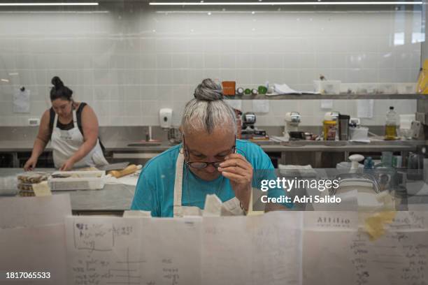 Volunteer adjusts her glasses while she begins to cook different recipes for sweet desserts to distribute to those in need on November 21, 2023 in...