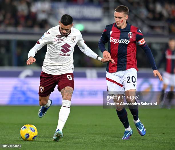 Antonio Sanabria of Torino FC passes the ball whilst under pressure from Michel Aebischer of Bologna FC during the Serie A TIM match between Bologna...