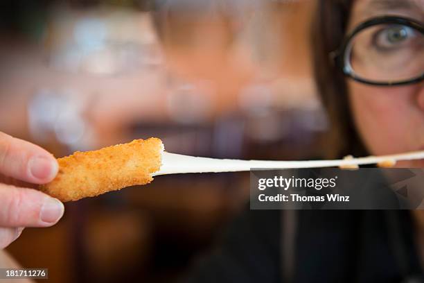 eating a cheese stick - cheese stick stock pictures, royalty-free photos & images